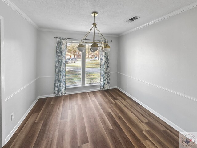 unfurnished dining area featuring dark hardwood / wood-style flooring, crown molding, and a textured ceiling