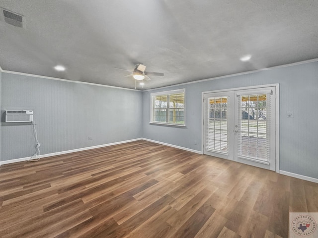 spare room featuring ornamental molding, french doors, hardwood / wood-style floors, and a wall unit AC