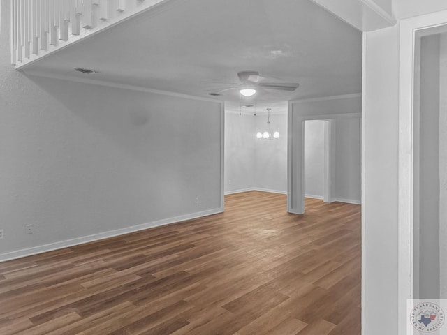 unfurnished living room with ceiling fan with notable chandelier and hardwood / wood-style floors