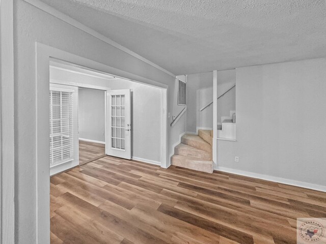 spare room with hardwood / wood-style floors, a textured ceiling, and french doors