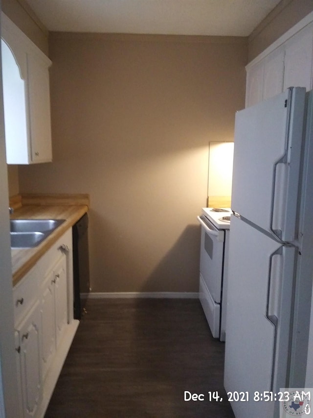 kitchen with white appliances, dark hardwood / wood-style floors, white cabinets, sink, and wood counters