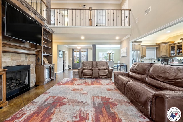 5710 Clearwood Trl, Texarkana, AR 71854 - living room featuring a high ceiling, crown molding, a stone fireplace, a chandelier, and baseboards