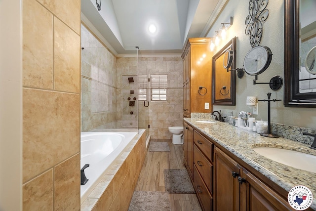 5710 Clearwood Trl, Texarkana, AR 71854 - full bathroom with a relaxing tiled tub, toilet, double vanity, tiled shower, and wood finished floors