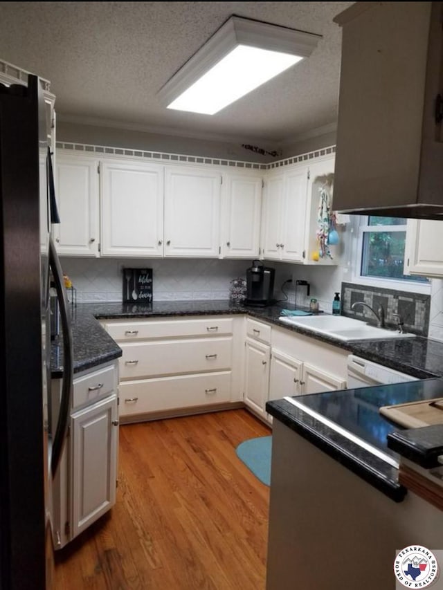24 Desoto Cir, Texarkana, TX 75503 - kitchen with freestanding refrigerator, a textured ceiling, white cabinets, and light wood-style floors