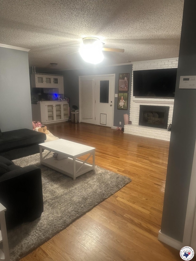 24 Desoto Cir, Texarkana, TX 75503 - living area featuring a textured ceiling, wood finished floors, a fireplace, and ceiling fan