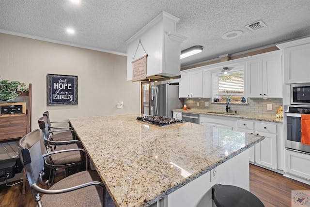 kitchen with sink, a kitchen breakfast bar, white cabinets, and stainless steel appliances