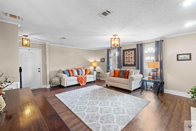 living room with dark wood-type flooring, a textured ceiling, and ornamental molding