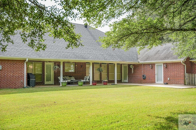 back of house featuring a lawn and a patio