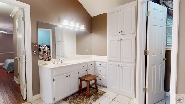 bathroom featuring vanity, vaulted ceiling, and tile patterned flooring