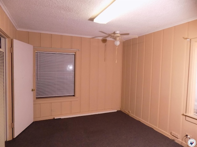 4024 Main St, Texarkana, TX 75503 - empty room with ceiling fan, a decorative wall, dark carpet, and a textured ceiling