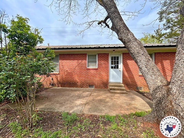 120 N St, Douglassville, TX 75560 - rear view of house featuring metal roof, crawl space, entry steps, brick siding, and a patio area