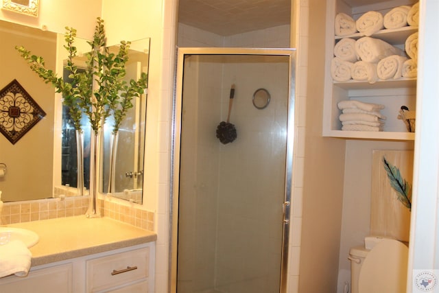 bathroom featuring vanity, toilet, and an enclosed shower