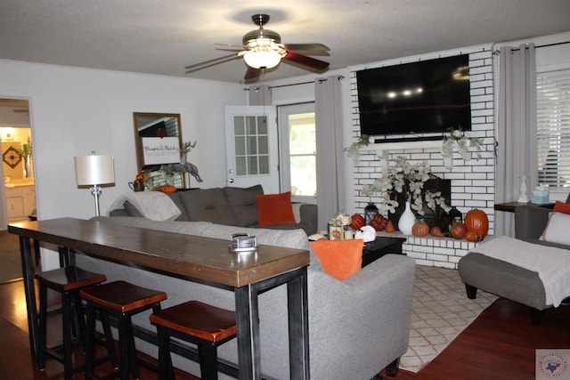 living room featuring ceiling fan and a fireplace