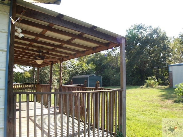 exterior space with a lawn, ceiling fan, and a shed