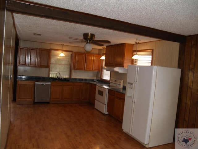 kitchen with sink, decorative light fixtures, hardwood / wood-style floors, white appliances, and a textured ceiling