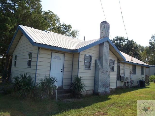 view of front of house featuring a front yard, cooling unit, and central air condition unit