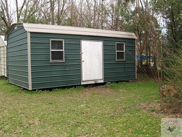 view of outbuilding featuring a lawn