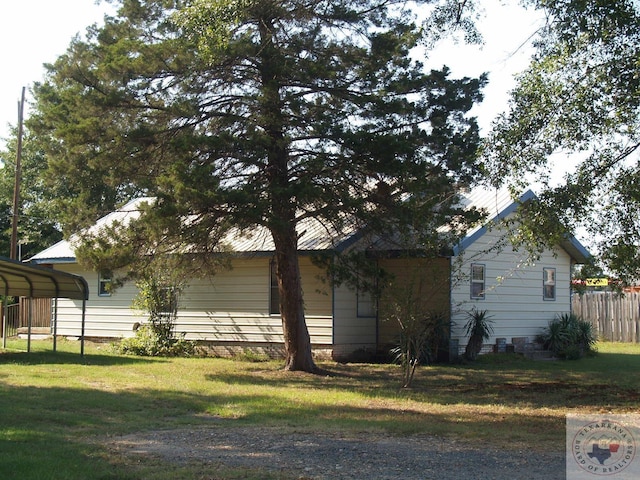 view of side of property with a yard and a carport