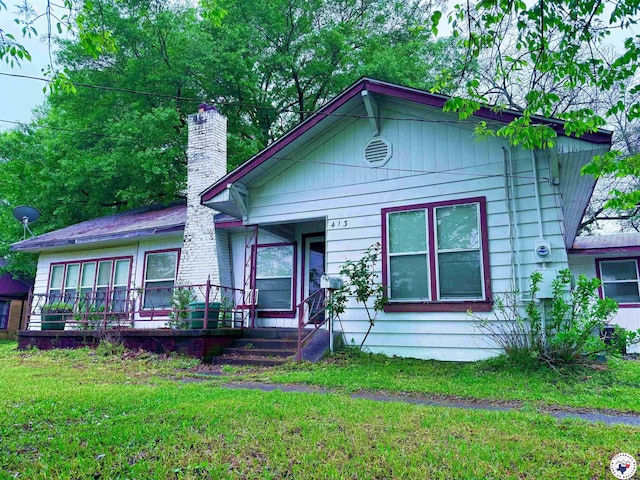 view of front of property with a front yard and a chimney