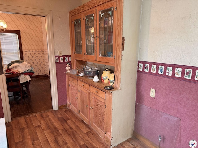 hallway with baseboards, wallpapered walls, and wood finished floors