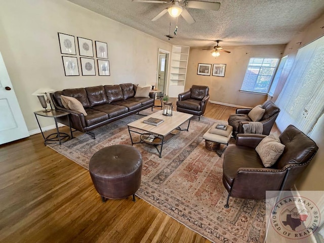 living room featuring ceiling fan, hardwood / wood-style floors, and a textured ceiling