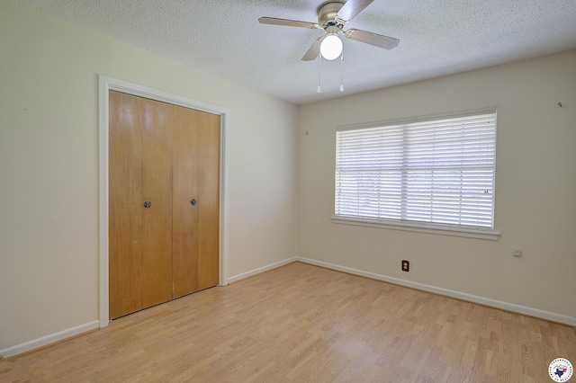 814 Hawkins Ave, Wake Village, TX 75501 - unfurnished bedroom with wood finished floors, a textured ceiling, a closet, baseboards, and a ceiling fan