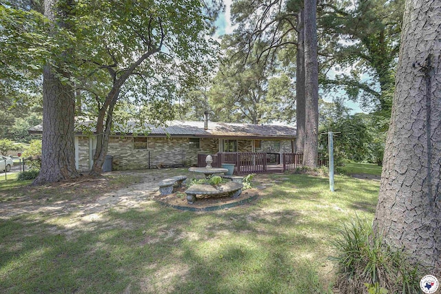 814 Hawkins Ave, Wake Village, TX 75501 - rear view of house featuring stone siding, a wooden deck, and a yard