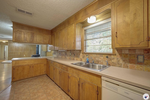 814 Hawkins Ave, Wake Village, TX 75501 - kitchen featuring dishwasher, a sink, decorative backsplash, light countertops, and a textured ceiling