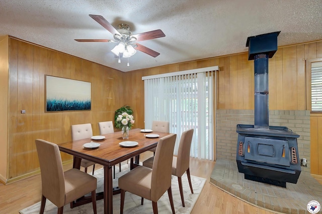 814 Hawkins Ave, Wake Village, TX 75501 - dining area with a textured ceiling, light wood finished floors, healthy amount of natural light, wooden walls, and a ceiling fan