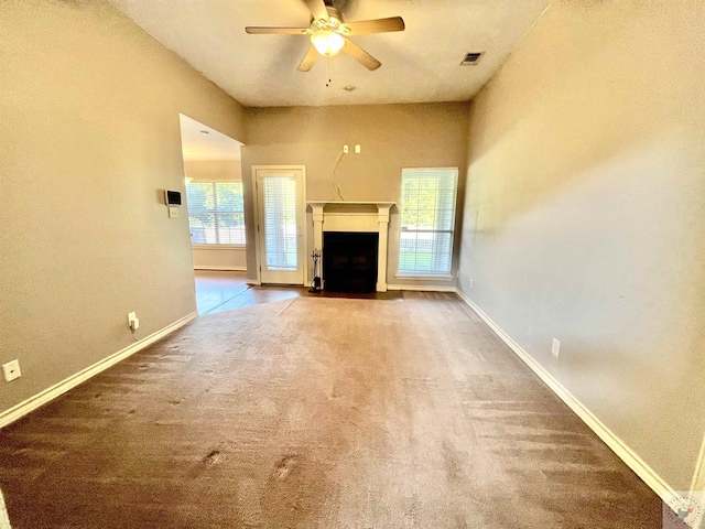 unfurnished living room featuring ceiling fan, a healthy amount of sunlight, and carpet flooring