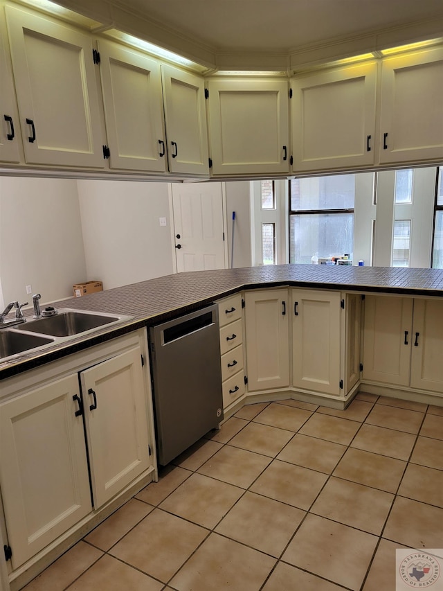 kitchen featuring sink, dishwashing machine, and light tile patterned flooring