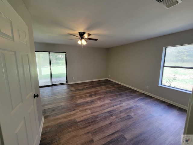 unfurnished room featuring plenty of natural light, ceiling fan, and dark hardwood / wood-style flooring