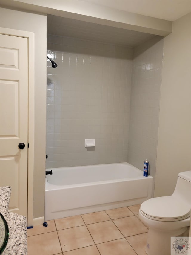 bathroom with toilet, tile patterned floors, and tiled shower / bath combo