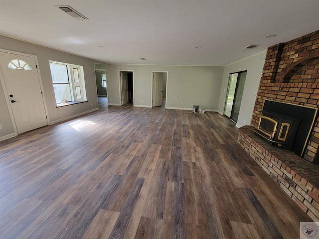 unfurnished living room with a wood stove and dark hardwood / wood-style flooring