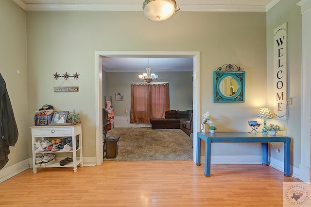 interior space featuring light hardwood / wood-style flooring, ornamental molding, and an inviting chandelier