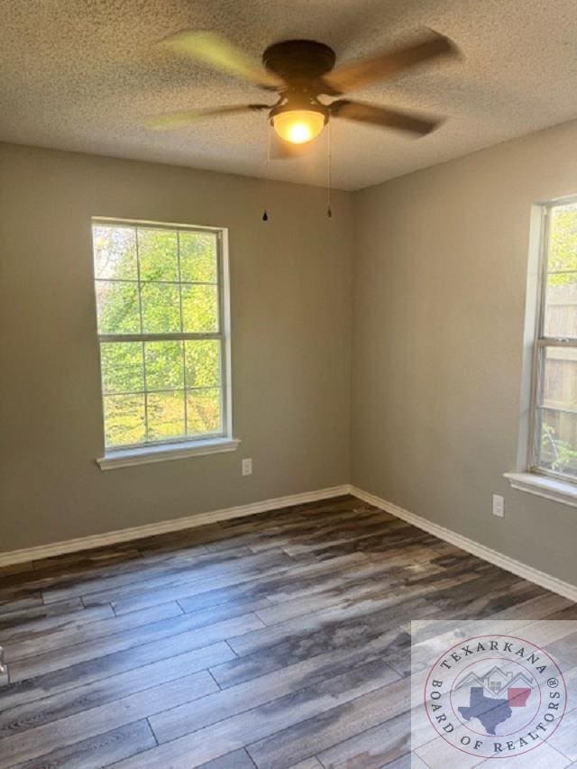 unfurnished room with wood-type flooring, a textured ceiling, ceiling fan, and a healthy amount of sunlight