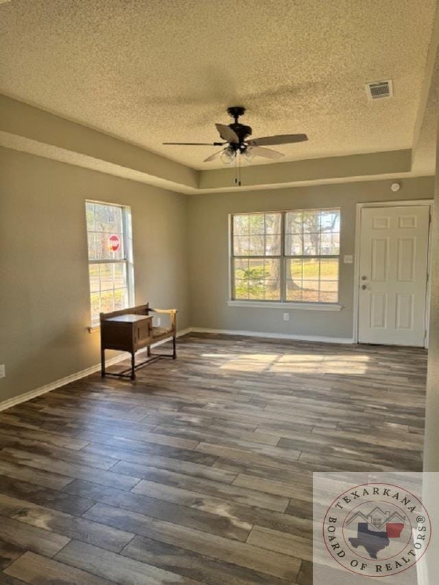 unfurnished room with ceiling fan, a textured ceiling, and dark hardwood / wood-style flooring