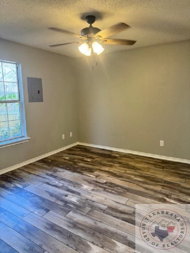 unfurnished room featuring hardwood / wood-style flooring, ceiling fan, electric panel, and a textured ceiling