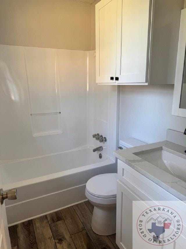 full bathroom with shower / washtub combination, hardwood / wood-style flooring, toilet, and vanity