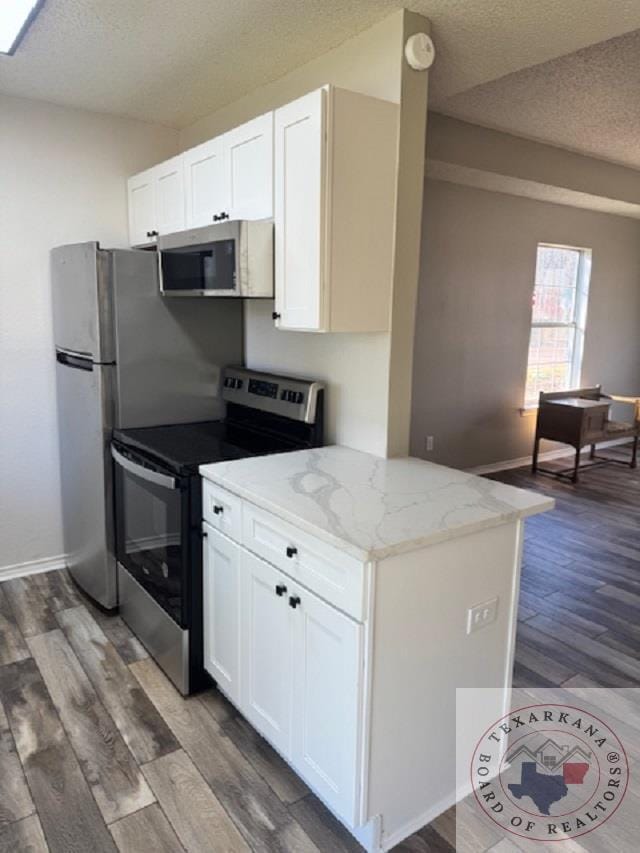 kitchen featuring light stone counters, white cabinetry, dark hardwood / wood-style floors, and stainless steel appliances