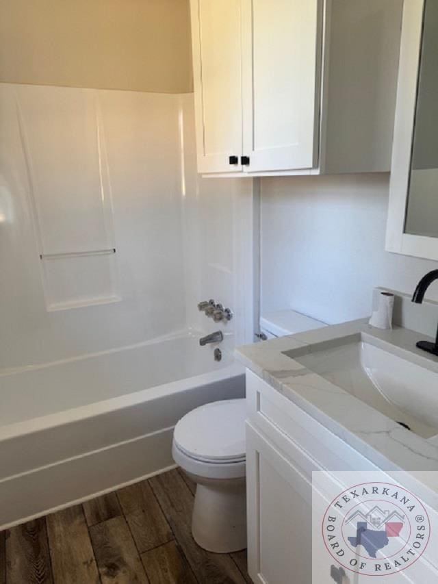 full bathroom featuring vanity, bathing tub / shower combination, hardwood / wood-style floors, and toilet