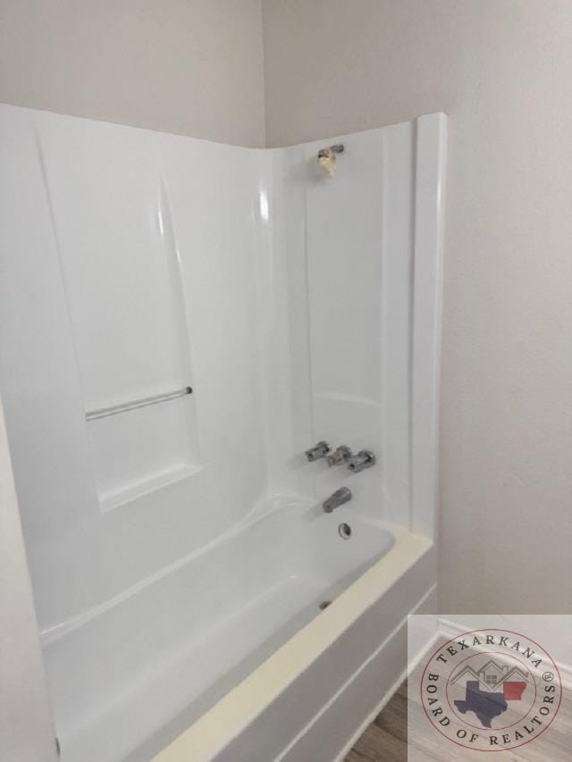 bathroom featuring hardwood / wood-style flooring and bathing tub / shower combination