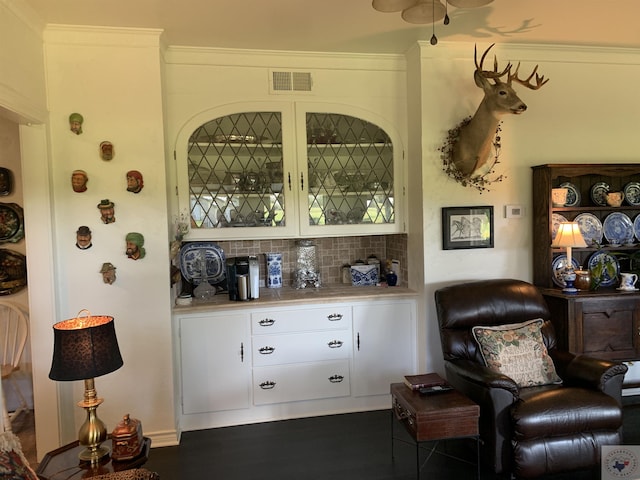 bar featuring backsplash and white cabinets