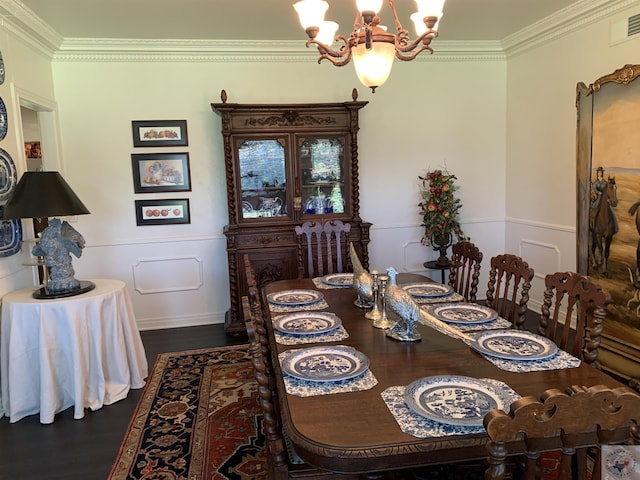 dining area with dark hardwood / wood-style flooring, crown molding, and an inviting chandelier