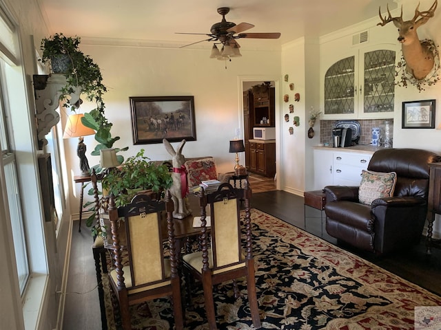 living room with ceiling fan, dark wood-type flooring, and crown molding