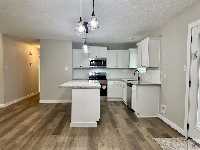 kitchen with sink, white cabinets, decorative backsplash, and stainless steel appliances