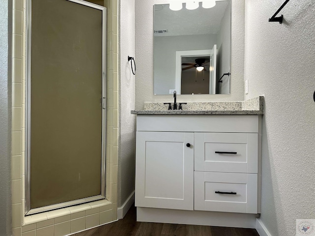 bathroom with wood-type flooring, an enclosed shower, and vanity