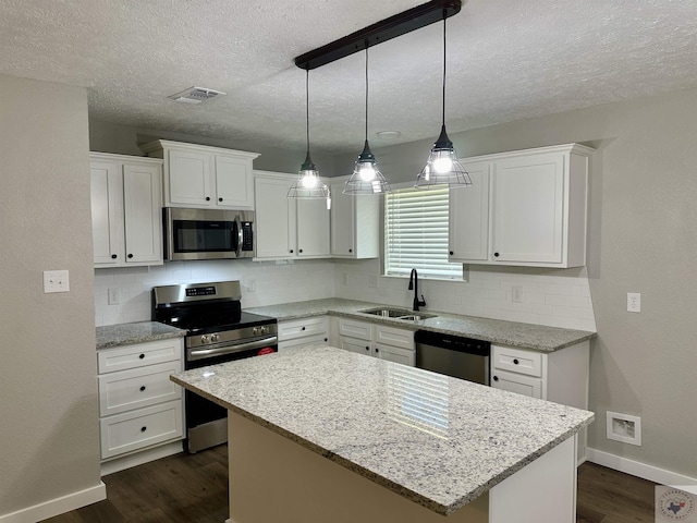 kitchen with sink, white cabinets, a center island, and stainless steel appliances