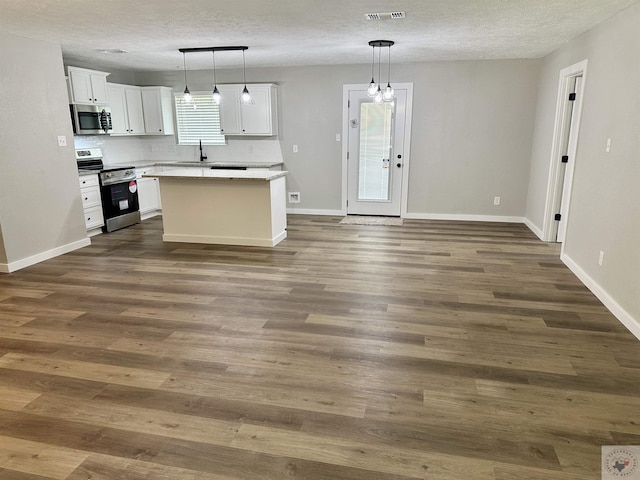 kitchen featuring pendant lighting, white cabinetry, stainless steel appliances, and a kitchen island