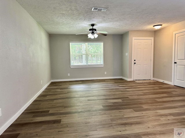 unfurnished room featuring ceiling fan, dark wood-type flooring, and a textured ceiling